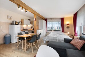 A compact living space with a kitchenette, dining area, and a bed. - Apartment 'Deichblick 3' with Shared Garden and Balcony (Hedwigenkoog)