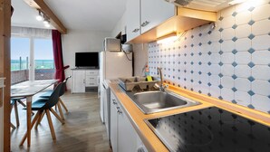 A compact kitchen with a wooden countertop, a sink, and a tiled backsplash. - Apartment 'Deichblick 3' with Shared Garden and Balcony (Hedwigenkoog)