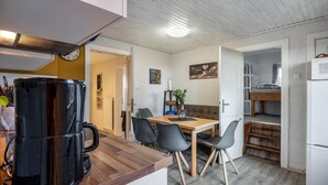 Una cocina compacta con cafetera, una mesa de comedor con sillas y un microondas.