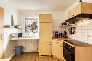Una cocina compacta con microondas, estufa y armarios de madera.