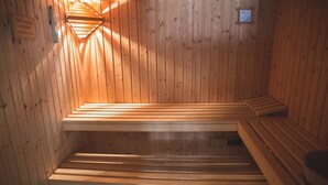Un sauna avec des bancs en bois et un radiateur fixé au mur.