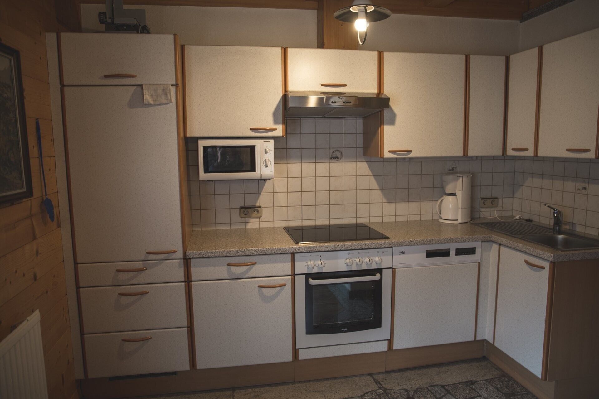 Une cuisine compacte équipée d’un four à micro-ondes, d’une cuisinière, d’un four et d’une machine à café.
