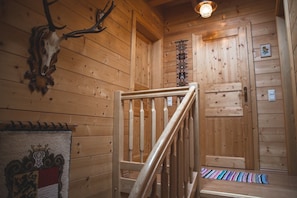 A wooden interior with a staircase, a wall-mounted deer skull, and a patterned rug. - Holiday Home 'Klippitzblick' with Private Terrace and Private Garden (Bad St. Leonhard)