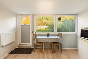Un petit coin repas comprenant une table, des chaises, un radiateur et un téléviseur.