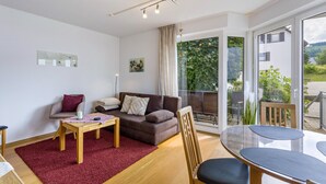 A modern living room with a sofa, a coffee table, and a dining table.