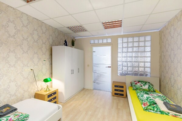 Une chambre à coucher comprenant un lit, une armoire, un bureau avec une lampe et une fenêtre donnant sur un beau paysage.