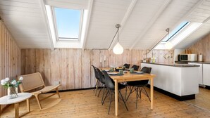 Un espacio tipo loft con comedor, cocina y tragaluces.