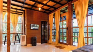 A spacious room with a large bed, a desk, and a television. - Ethnic Villa Wayanad (Sulthan Bathery)
