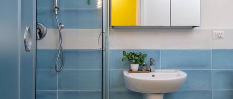 A bathroom with a shower, a sink, and a mirror.