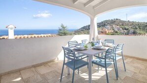 A terrace with a table set for dining, overlooking a coastal landscape with houses and a hill. - Beautiful private villa for 7 guests with private pool, A/C, WIFI, TV and patio (Budoni)