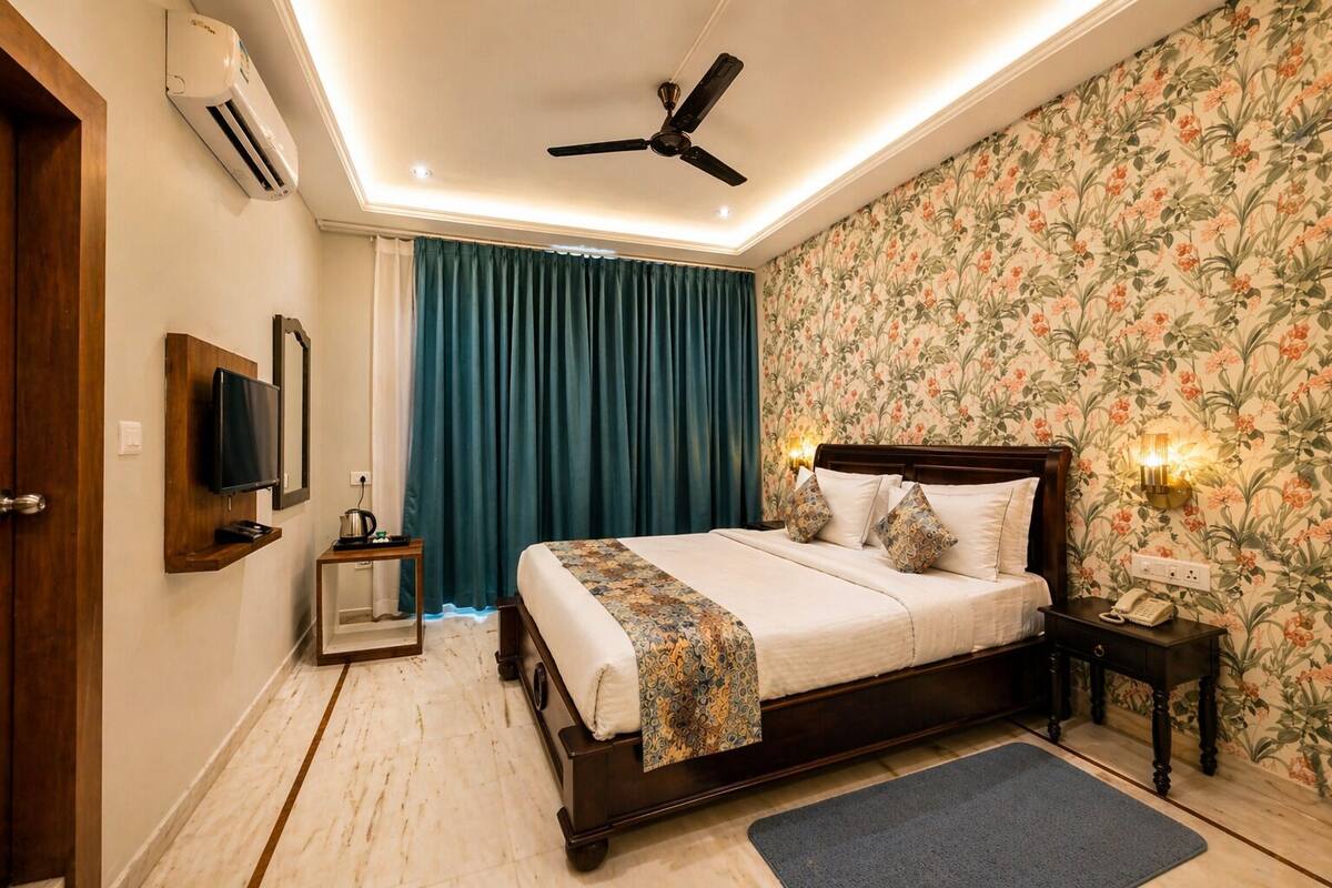 A bedroom with a bed, a ceiling fan, a TV, a bedside table, and a nightstand.