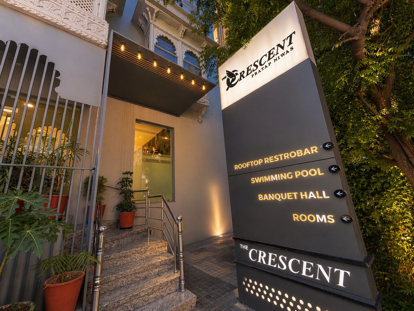 Señal de The Crescent con indicaciones hacia el restobar en la azotea, la piscina, el salón de banquetes y las habitaciones.