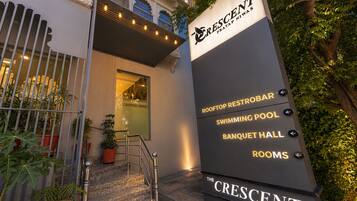 Señal de The Crescent con indicaciones hacia el restobar en la azotea, la piscina, el salón de banquetes y las habitaciones.