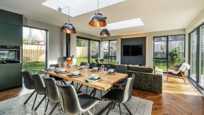 A modern kitchen with a built-in oven and a dining area with a wooden table and chairs.