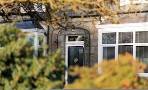 Um edifício com uma porta preta e uma placa acima que diz 'Blythewood'.