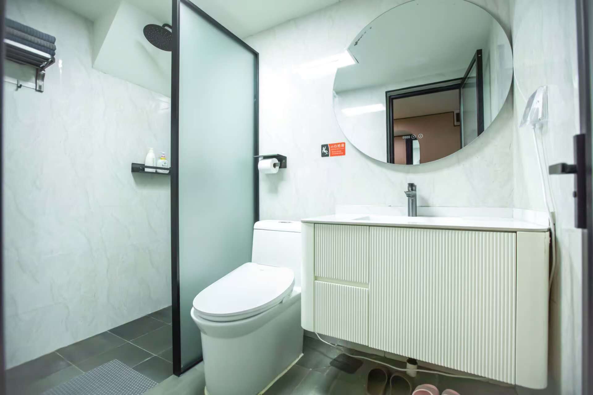 A modern bathroom with a toilet, sink, and shower.