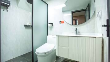 Un baño moderno con inodoro, lavabo y ducha.