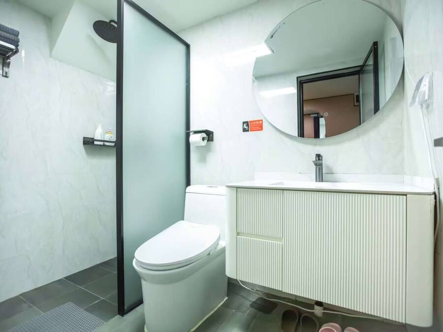 Un baño moderno con inodoro, lavabo y ducha.