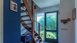 Una escalera lleva a una habitación con vistas a zonas verdes.