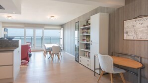 Una cocina moderna con comedor, una estantería y vistas al mar.