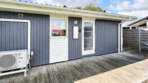 A single-story building with a covered porch, a small window, and a door. - 4 Star Holiday Home in Hejls (Hejls)