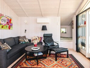 A modern living room with a black leather chair, a black coffee table, and a colorful rug. - 4 Star Holiday Home in Hejls (Hejls)