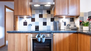 Une cuisine moderne avec des meubles en bois, une hotte en acier inoxydable et un four encastré.