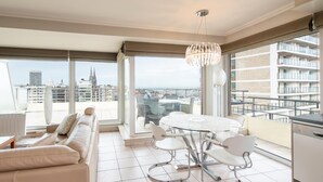Een moderne hotelkamer met een ruim balkon, een eethoek en uitzicht op de stadshemel.