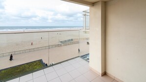 A balcony with a view of a beach and ocean.