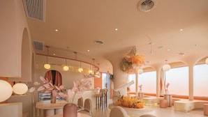 A modern dining area with round tables, chairs, and decorative flowers. - Qi Meng Rainbow bridge branch (Shanghai)