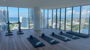 A spacious room with large windows offering a city view, equipped with exercise mats and weights. - La Jolla Holiday Broadbeach (Broadbeach)