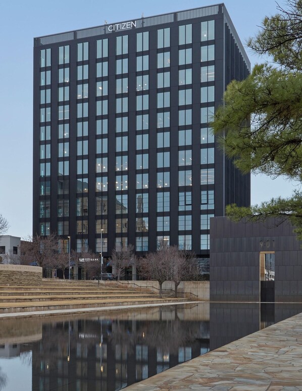 Un edificio moderno con un estanque reflectante en primer plano.
