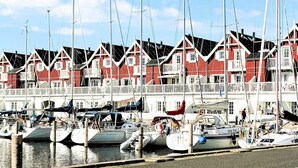 Ein Hafen mit roten und weißen Häusern und anlegenden Booten.