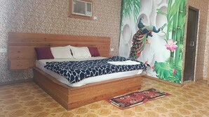 A bedroom with a wooden bed, patterned wallpaper, a peacock mural, and a door with a green bamboo design. - Krishna Raja Ji Downtown By GRB (Ganga Bhogpur Talla)