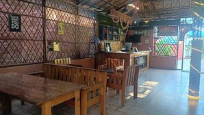 A restaurant with wooden furniture, a counter, and a decorative wall. - Krishna Raja Ji Downtown By GRB (Ganga Bhogpur Talla)