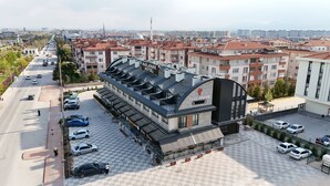 Un hotel de diseño moderno, con una entrada destacada, una terraza en la azotea y un área de estacionamiento.