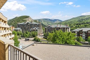 A hotel with multiple buildings, a parking area, and a mountainous backdrop. - Ski in, Ski Out at The Seasons @ Avon (Avon)