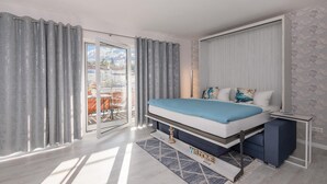 A modern bedroom with a bed, a bedside table, and a view through a sliding glass door to an outdoor area. - Düneneck 21 - lovingly designed one-room domicile (Zempin)