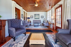 A spacious living room with a wooden ceiling, a large window, and a checkered coffee table. - Home Near Hiking Biking w Hottub 6 Bedrooms (Bennington)