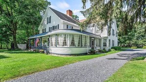 A large, two-story house with a wrap-around porch and a covered entryway. - Home Near Hiking Biking w Hottub 6 Bedrooms (Bennington)