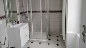 A modern bathroom with a glass-enclosed shower, white vanity, and a large mirror. - ART on the ground floor and terrace  (Beautheil-Saints)