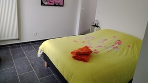A bedroom with a bed, a radiator, a door, and a wall-mounted picture. - ART on the ground floor and terrace  (Beautheil-Saints)