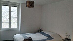 A bedroom with a bed, a window, and a nightstand. - ART on the ground floor and terrace  (Beautheil-Saints)