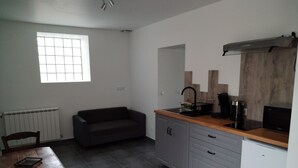 A compact kitchen with grey cabinets, a wooden countertop, a black coffee maker, and a small refrigerator. - ART on the ground floor and terrace  (Beautheil-Saints)