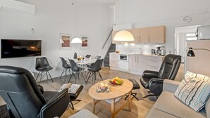 Eine moderne Wohnung mit Wohnzimmer, Essbereich, Küche und einer Treppe.