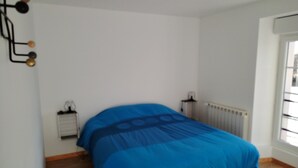 A bedroom with a bed, a radiator, and a window. - L' ART Appart from 2 to 4 pers, 7 min from coulommiers, 25 min from Disneyland Paris (Beautheil-Saints)