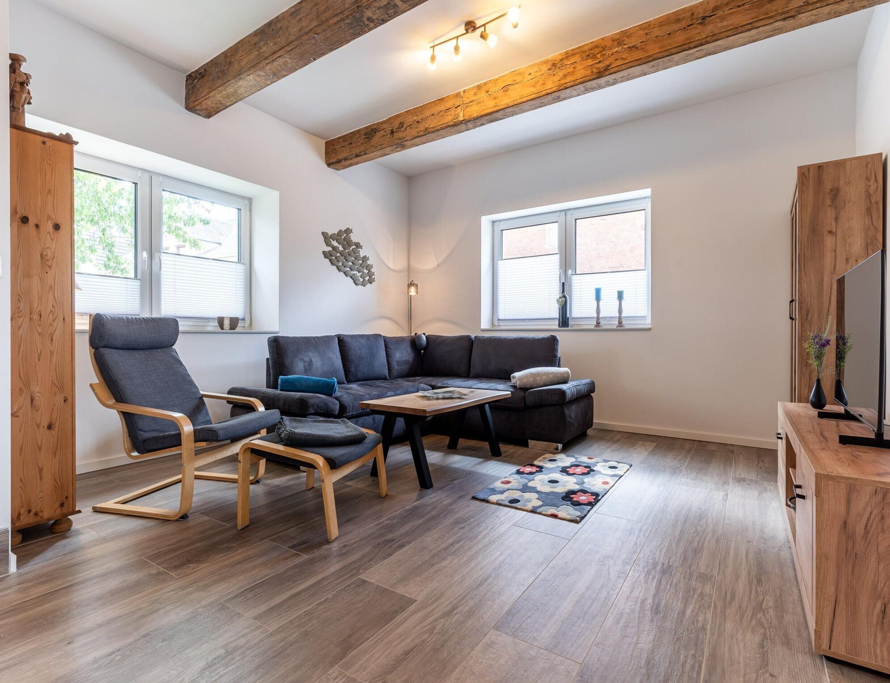 A modern living room with a sectional sofa, a wooden coffee table, and a TV stand.