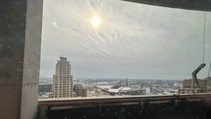 A view from a window overlooking a cityscape with a prominent building and a stadium. - 2BR/3BA combined apartments with  city views (Cleveland)