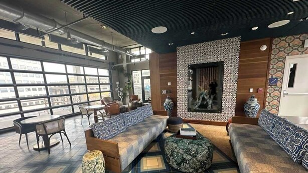 Een moderne lounge met een groot raam, een patroon vloer en zitopstellingen.
