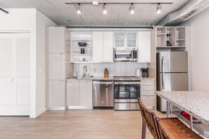 A modern kitchen with white cabinets, stainless steel appliances, and a granite countertop. - 7 Combined units with Stunning City Views (Cleveland)